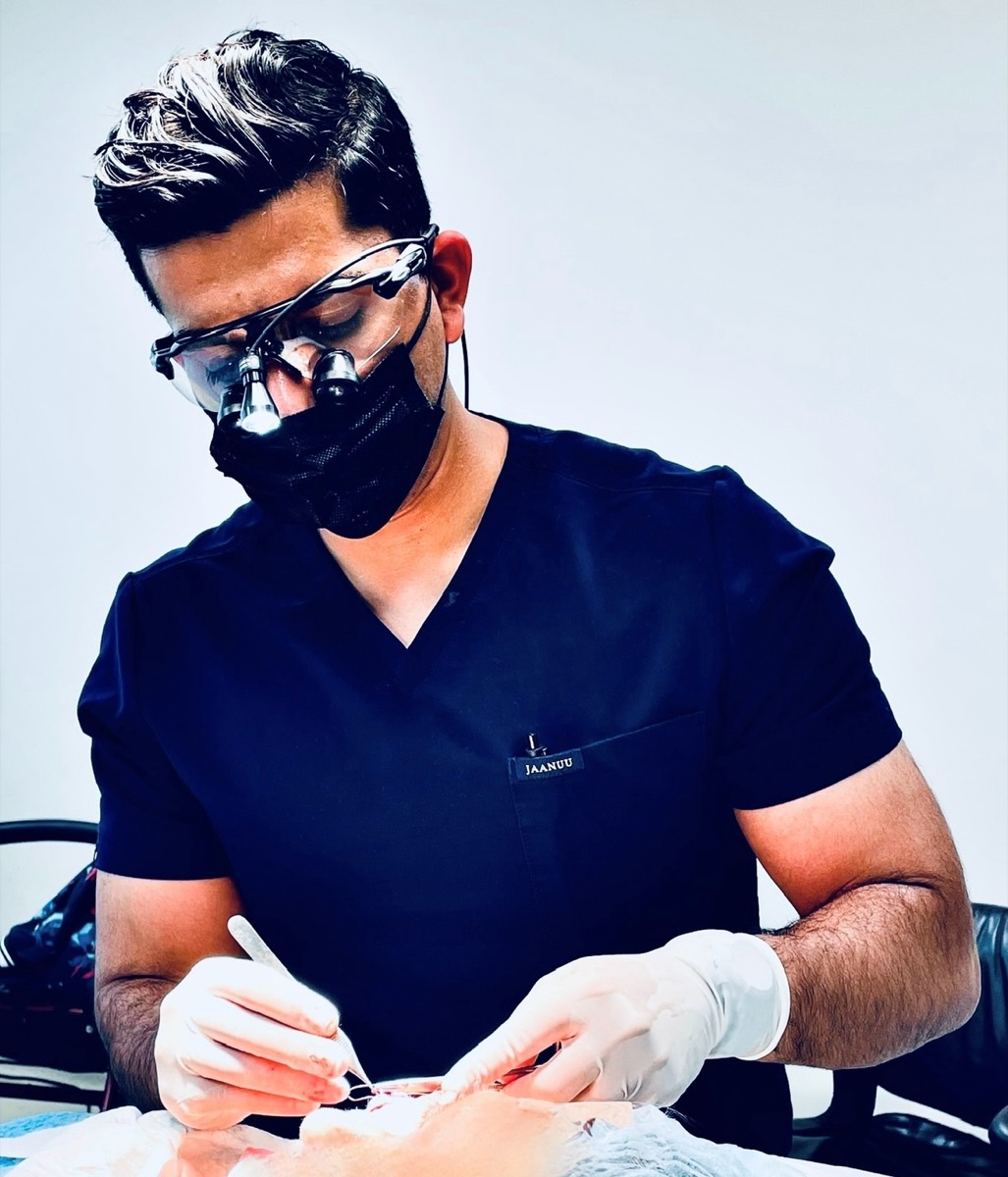 Dr. Om performing Mohs surgery wearing surgical loupes